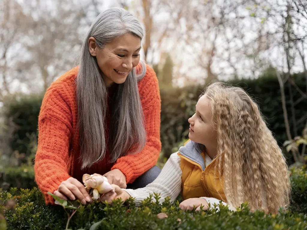 Senior picking flowers with grand daughter