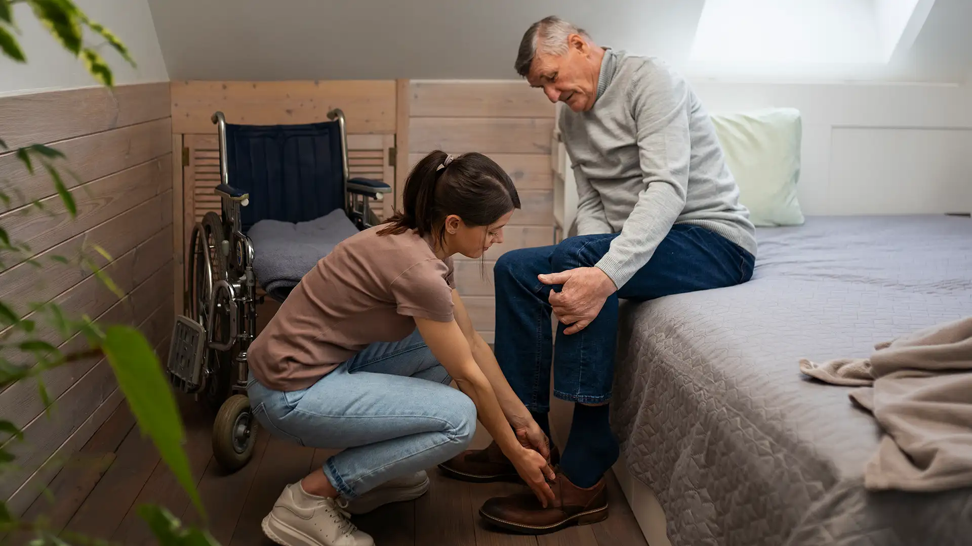 Helping elderly man iwih shoes