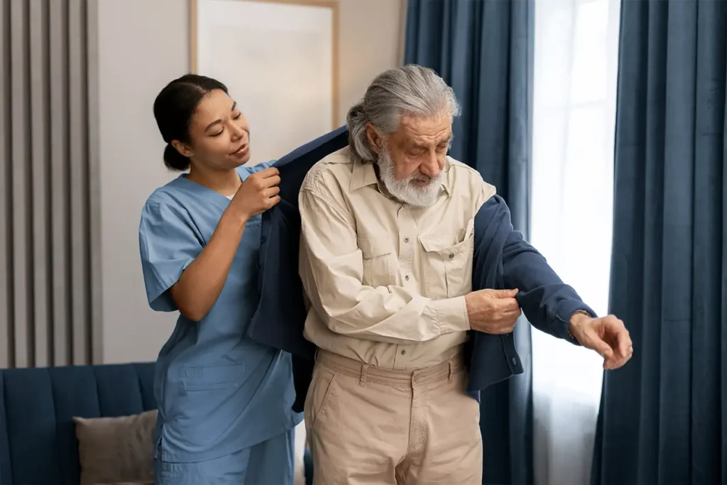 Nurse helping with mans coat