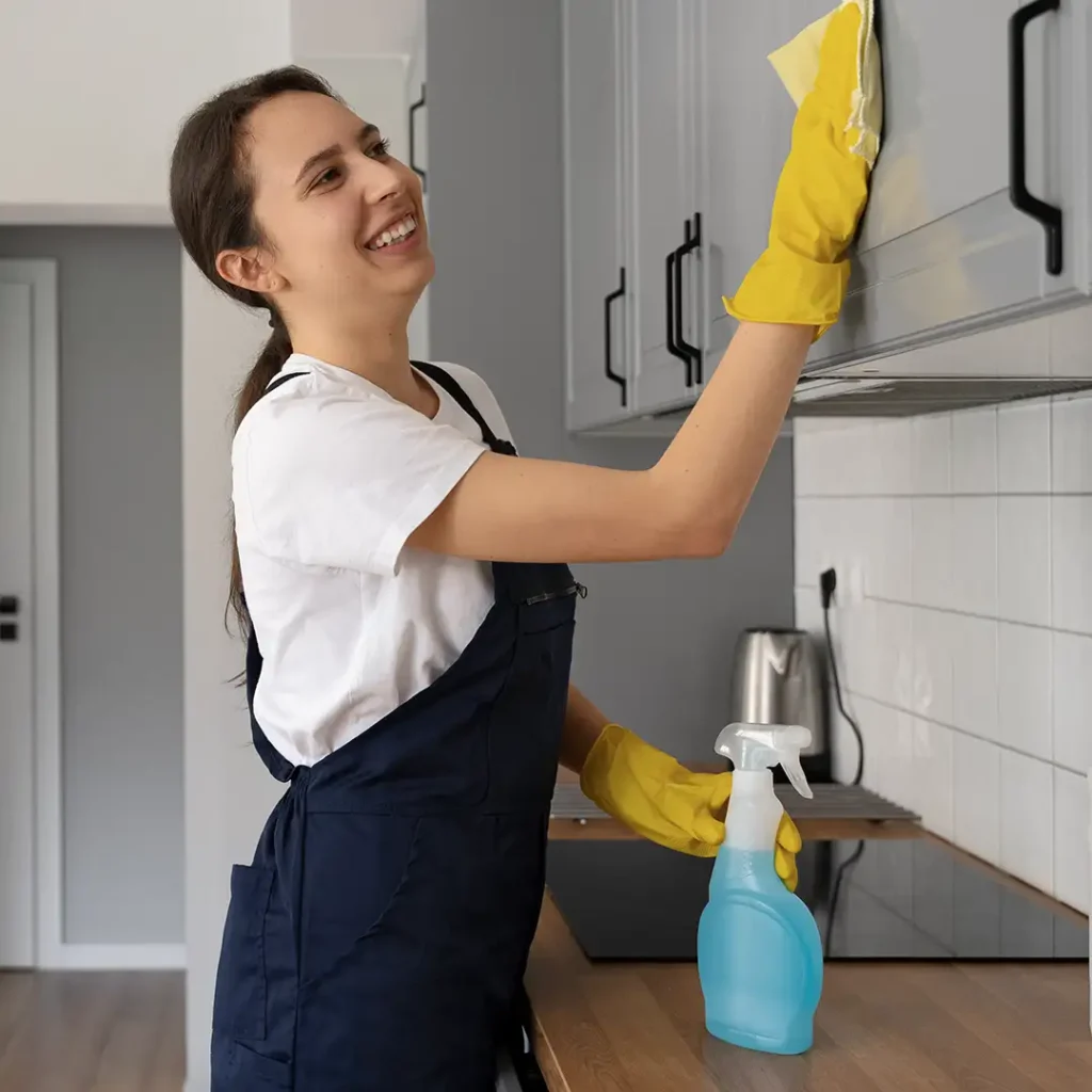 Woman cleaning kitchen in yellow gloves